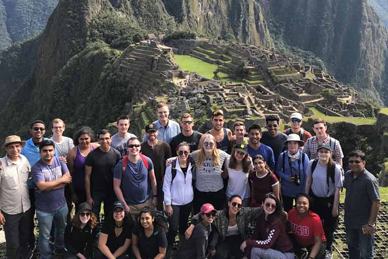 student group in brazil with mountains and ruins in background