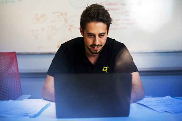 student sitting while working on laptop