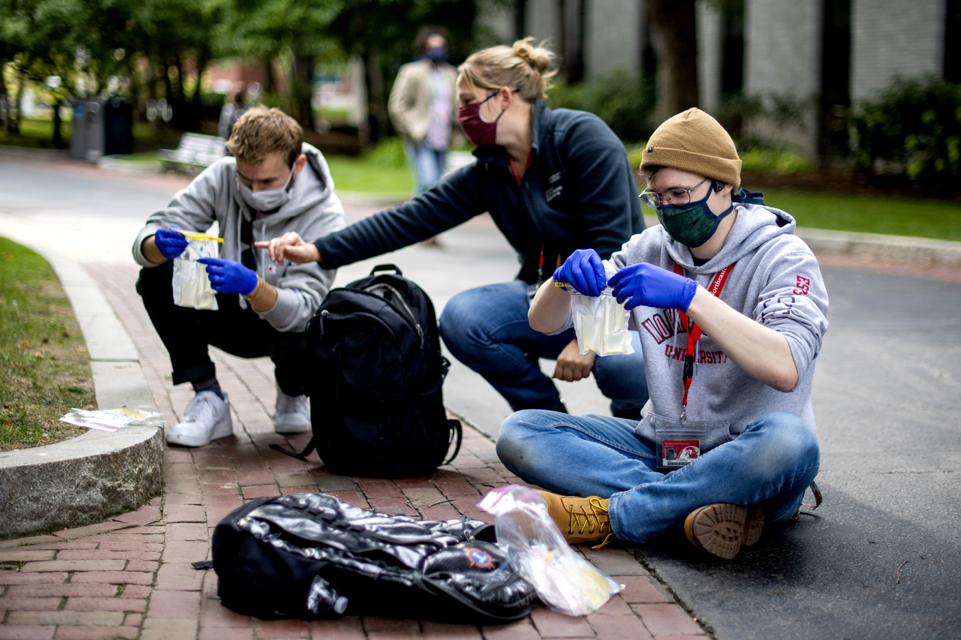 Kelsey Pieper with two students working outside on campus