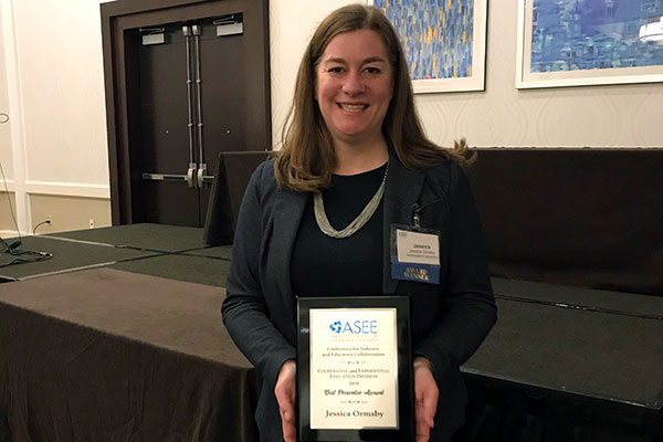 professor showing framed award