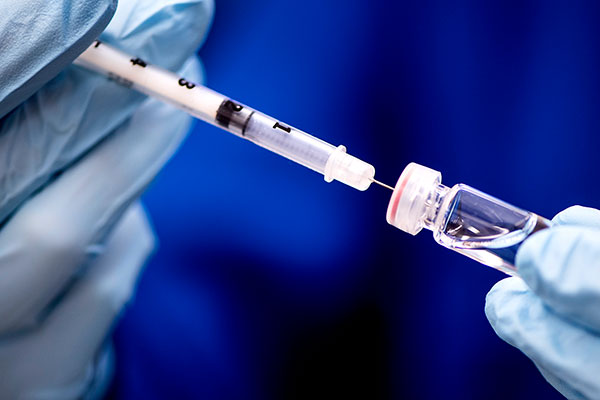 needle being put into vaccine tube