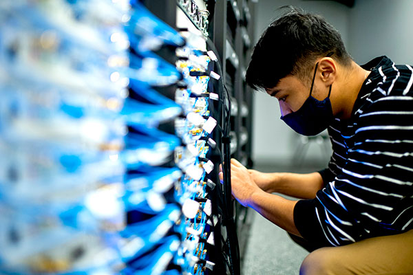 student works on wireless rack in data center