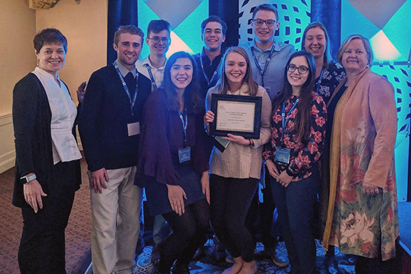 students pose with award
