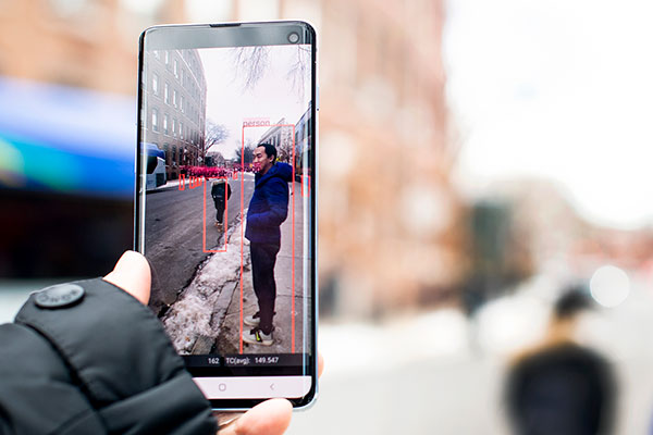someone holding a mobile phone with measurements showing up in real time