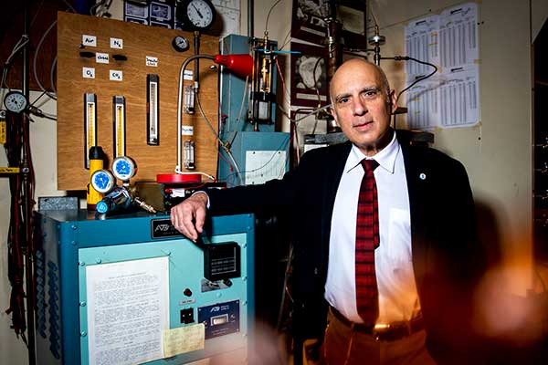 Levendis standing in front of furnace.