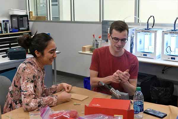 two students at table with project