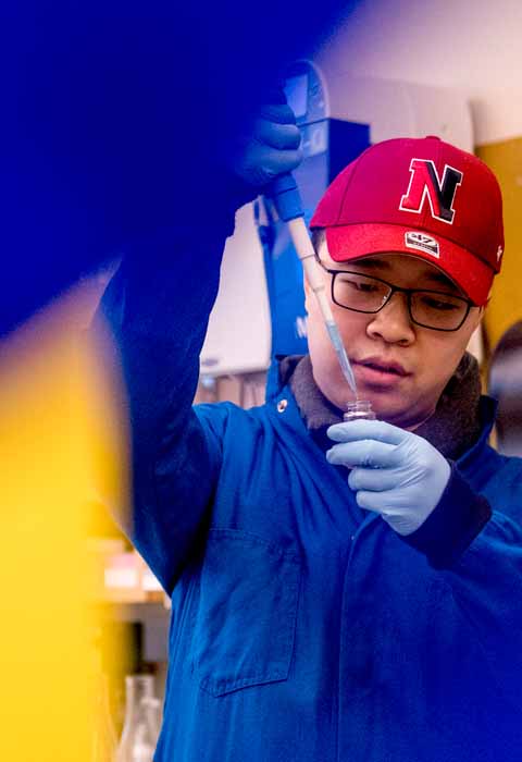 phd student squirting chemicals in small tube